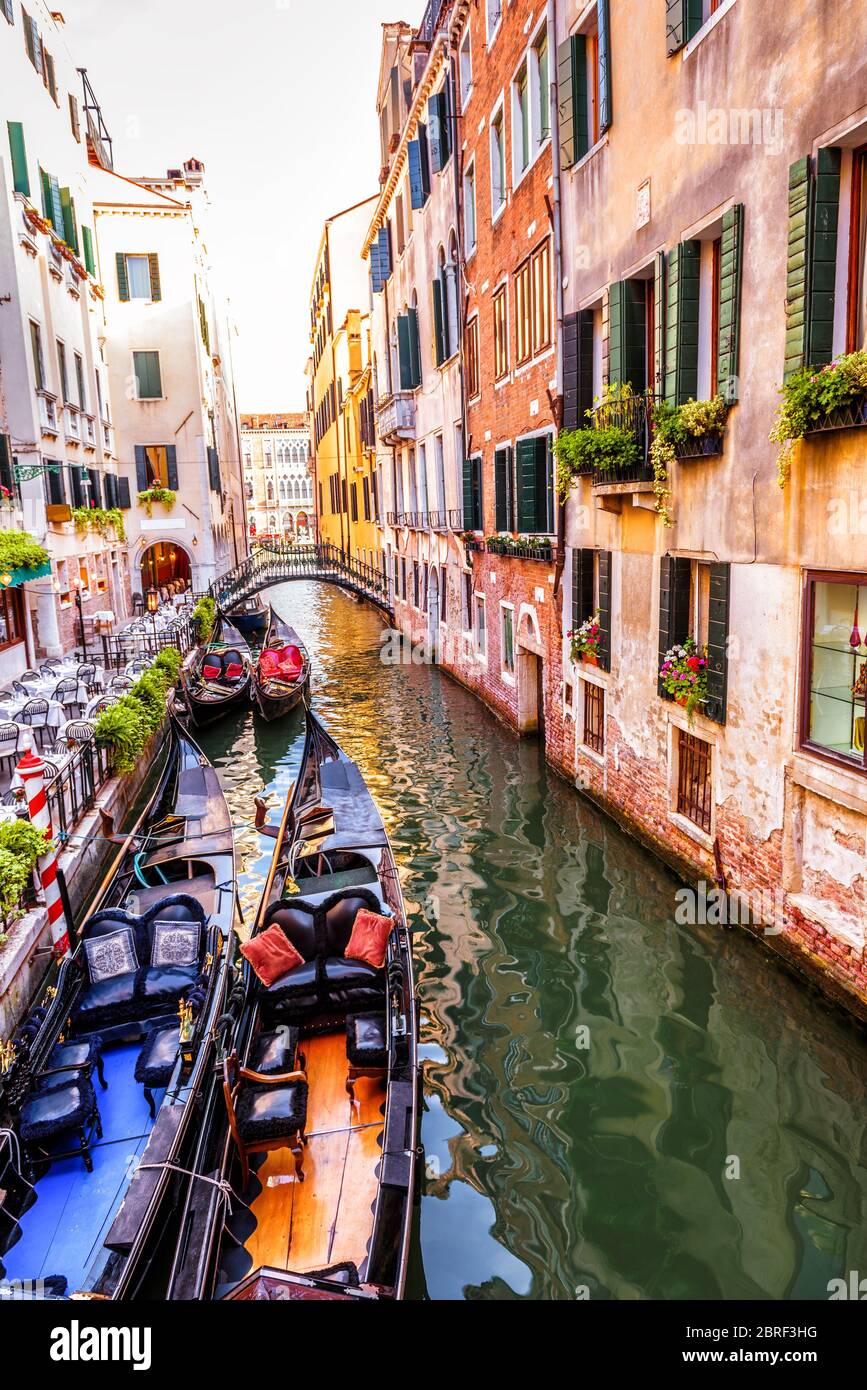 Straße mit vertäuten Gondeln und Café, Venedig, Italien. Im Sommer Blick auf den Kanal von Venedig. Bunte Vintage Häuser von Venedig mit Blumen. Romant Stockfoto