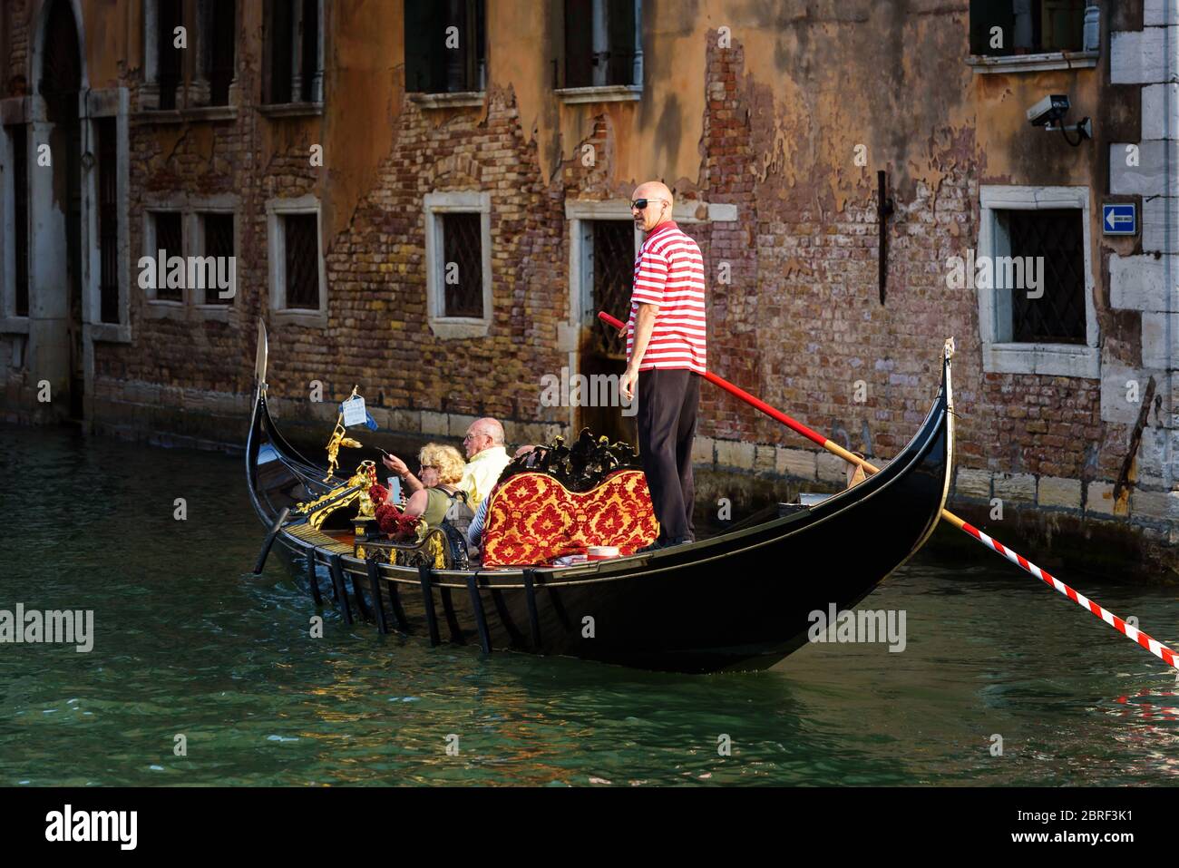 Venedig, Italien - 18. Mai 2017: Gondel mit Menschen fährt auf einem alten Kanal in Venedig. Gondel ist ein sehr attraktiver Touristenverkehr in Venedig. Romantisch Stockfoto