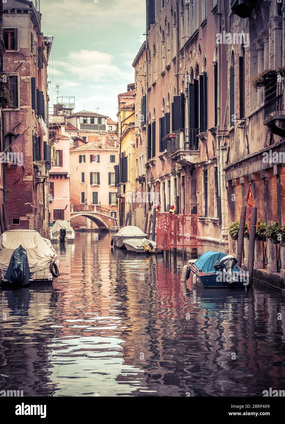 Alte Straße mit geparkten Booten, Venedig, Italien. Schöne vertikale Ansicht des Kanals von Venedig mit Reflexionen im Wasser. Historische Gebäude und Stadtbild des Ehrw Stockfoto