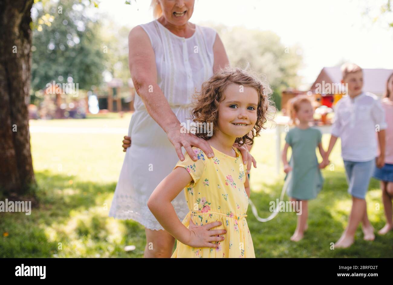 Kleine Kinder im Freien im Garten im Sommer, spielen. Stockfoto