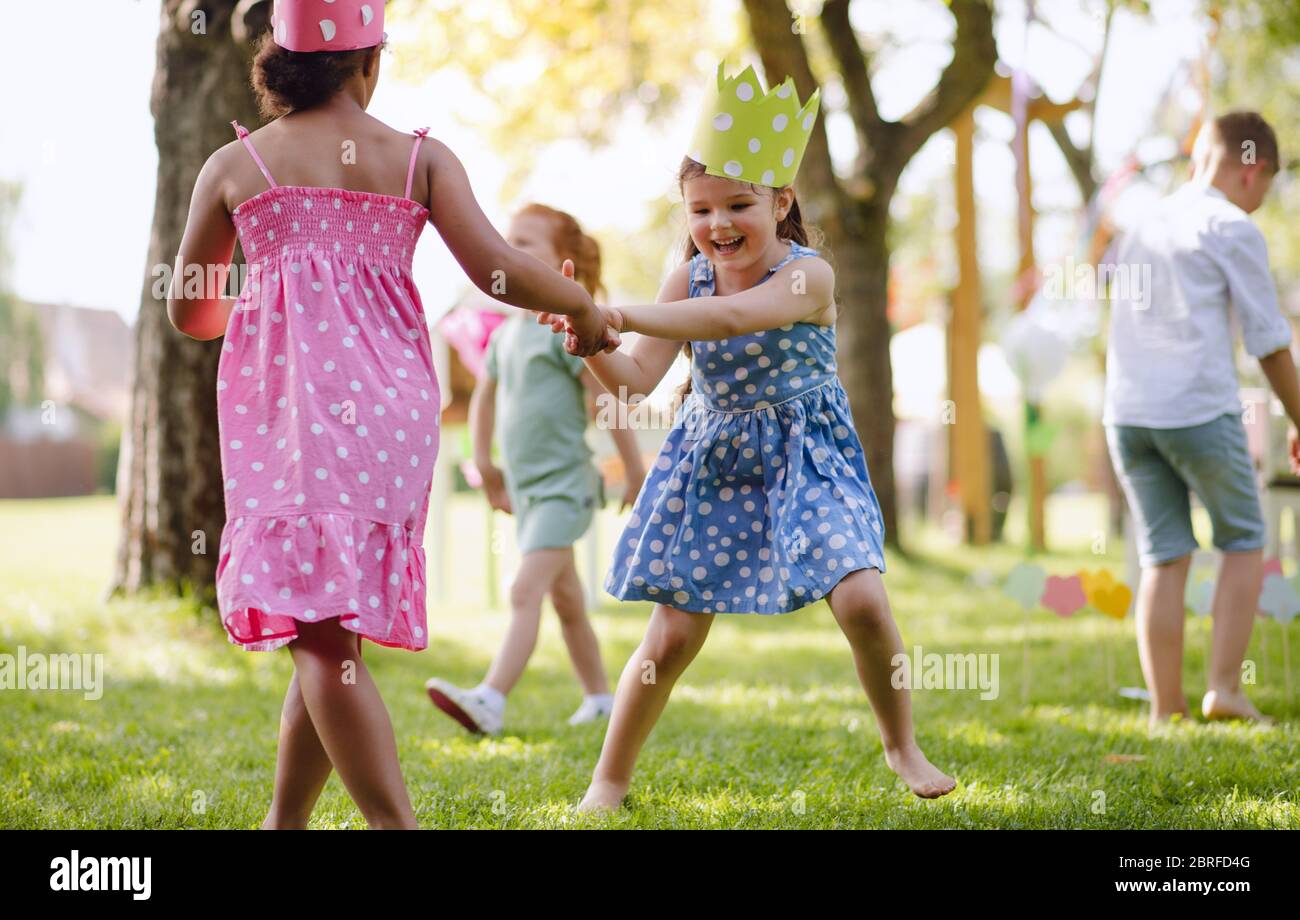 Kleine Kinder stehen im Sommer im Garten und spielen. Stockfoto