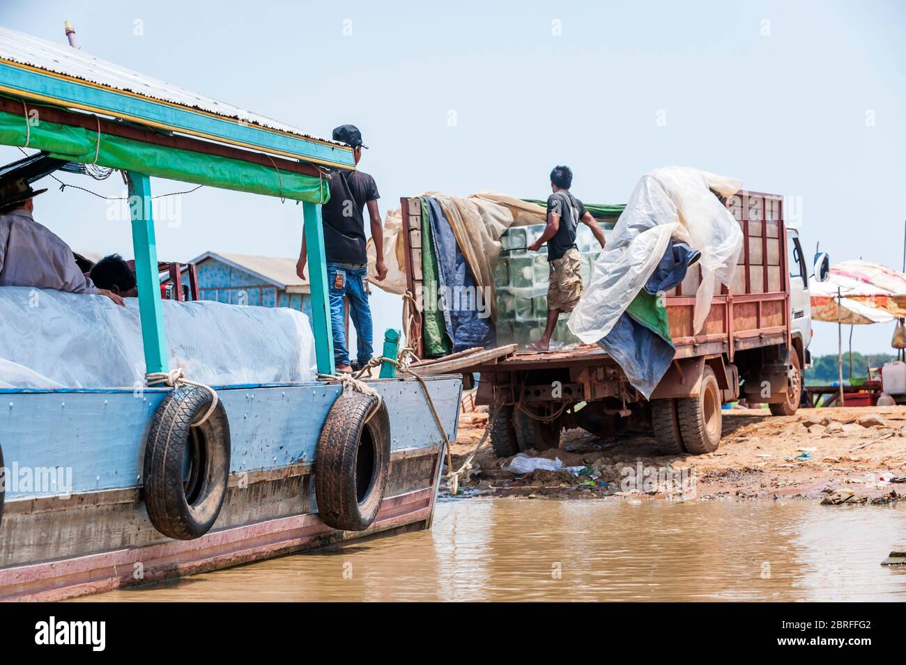 LKW-Lieferung von Eis auf ein Boot im schwimmenden Dorf Kompong Luong verladen. Krakau, Kambodscha, Südostasien Stockfoto