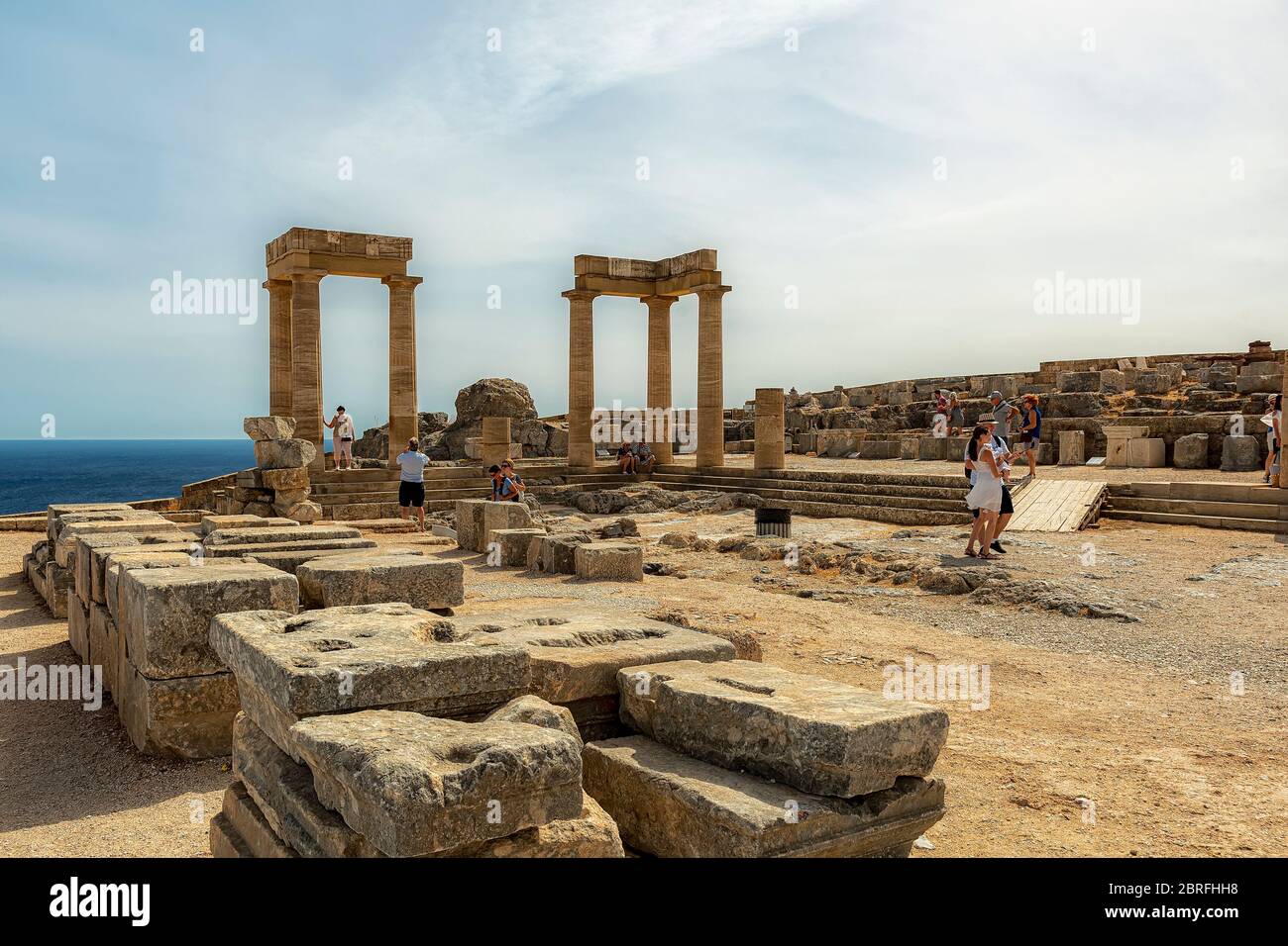 LINDOS, GRIECHENLAND - 04. OKTOBER 2018: Einige Touristen an der Akropolis von Lindos auf der griechischen Insel Rhodos. Stockfoto