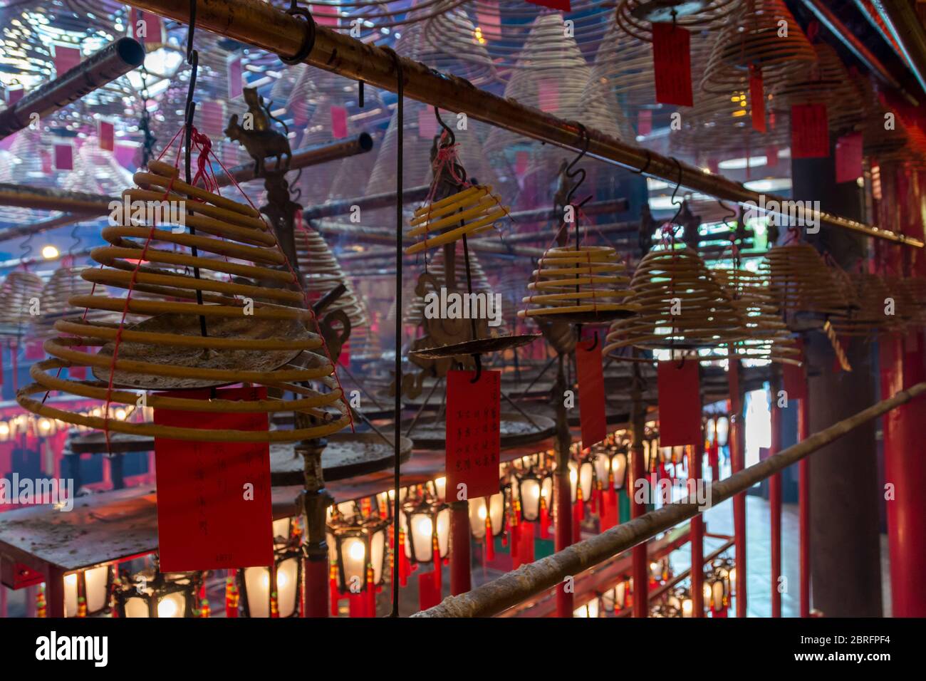Weihrauchspulen hängen von der Decke, mit Gebeten auf roten Etiketten, die an ihnen angebracht sind, im man Mo Tempel, Hongkong, China, Asien Stockfoto