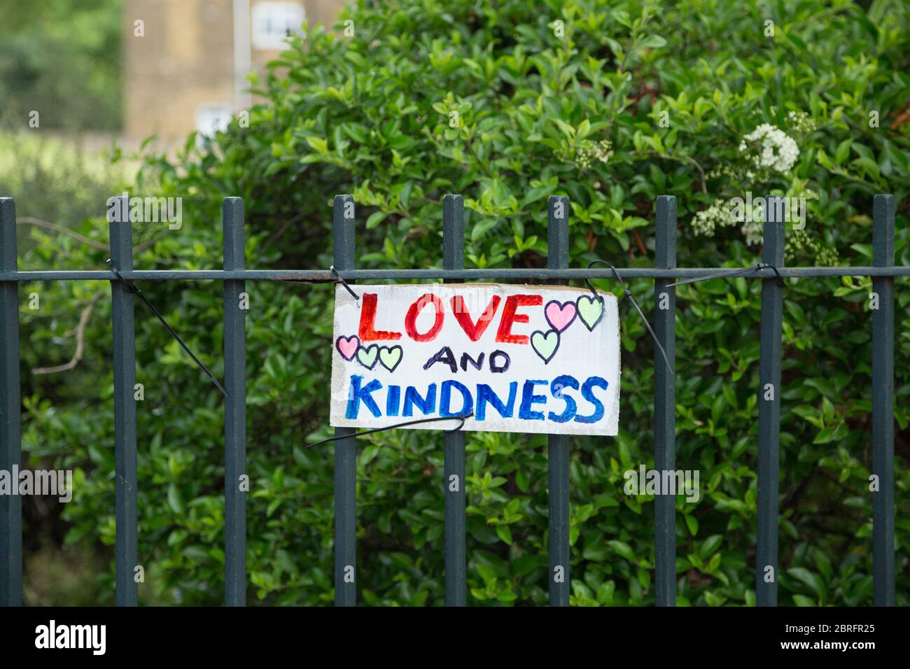 Ein selbstgemachtes Kunstwerk mit dem Slogan Liebe und Freundlichkeit und Herzsymbolen, die während der Coronavirus-Pandemie auf den Parkgeländern im Norden Londons ausgestellt sind Stockfoto
