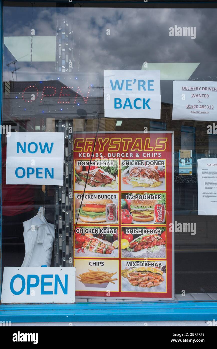 "Jetzt geöffnet" Schilder im Fenster eines High-Street-Imbissbuden in Südostengland sagen Öffentlichkeit, dass der Kebab-Shop während der Coronavirus Covid-19 Sperre geöffnet ist Stockfoto