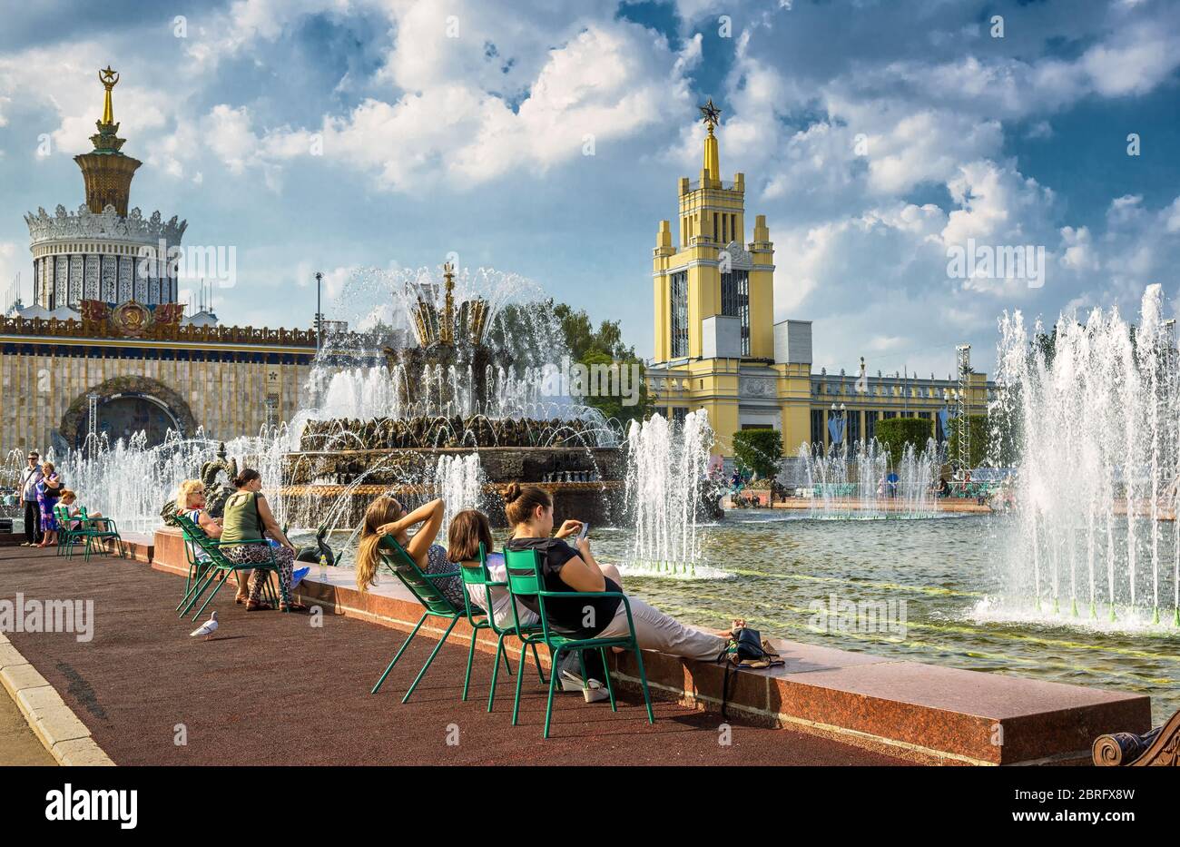 MOSKAU - 29. JULI 2016: Touristen ruhen sich in der Nähe des Steinblumenbrunnens im All-Russia Exhibition Centre (VDNKh) aus. Dieser Brunnen wurde 1954 erbaut. Stockfoto