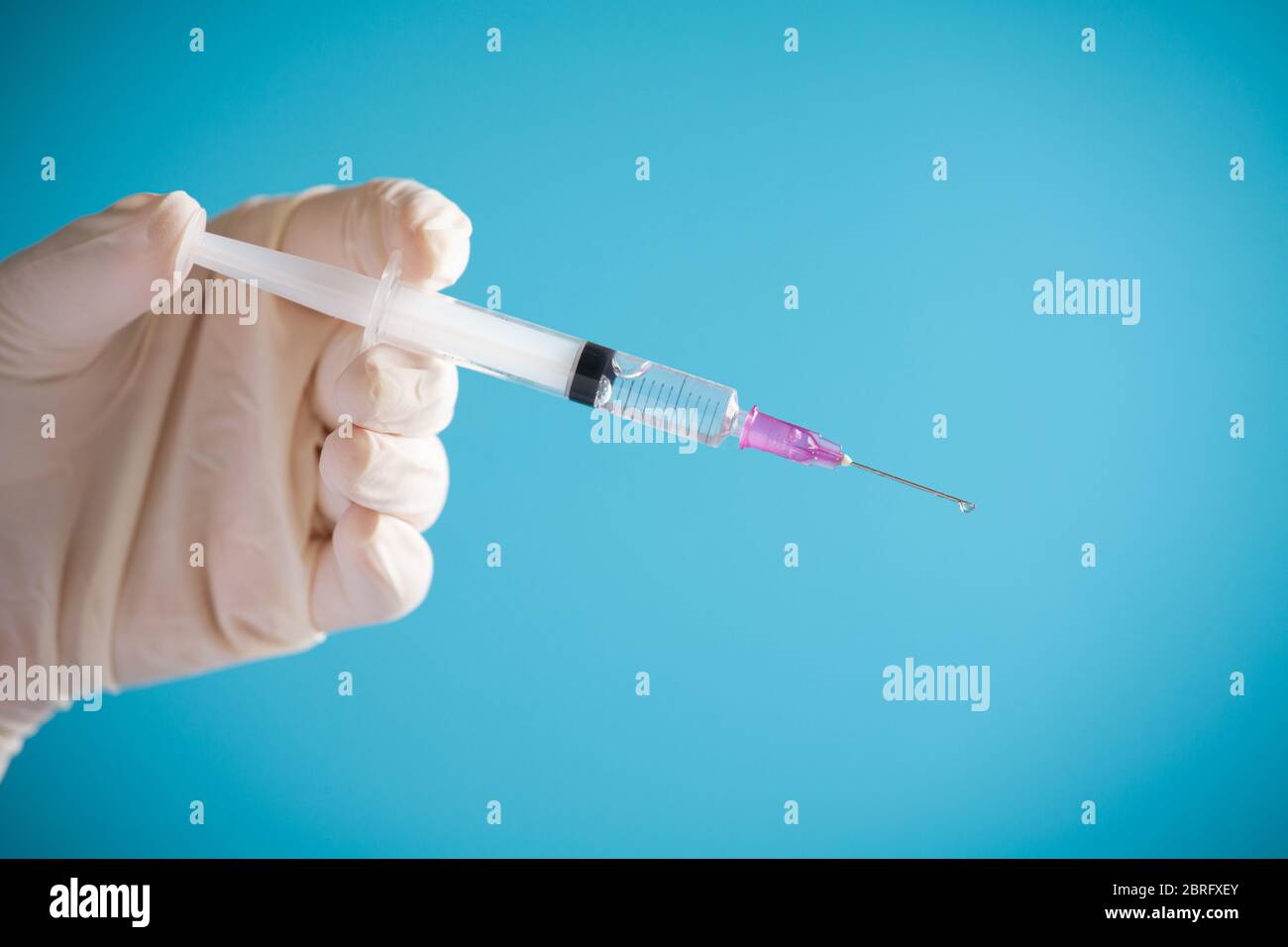 Doctor Hand halten Spritze Impfstoff für Corona-Virus auf isolieren blauen Hintergrund Konzept für Coronavirus Pandemie Krankheit, COVID-19 Virus aus Epidemie ou Stockfoto
