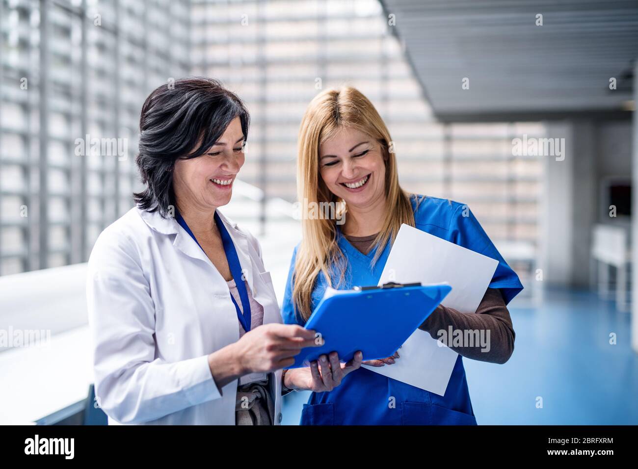 Ärztinnen stehen auf einer medizinischen Konferenz im Korridor und sprechen. Stockfoto