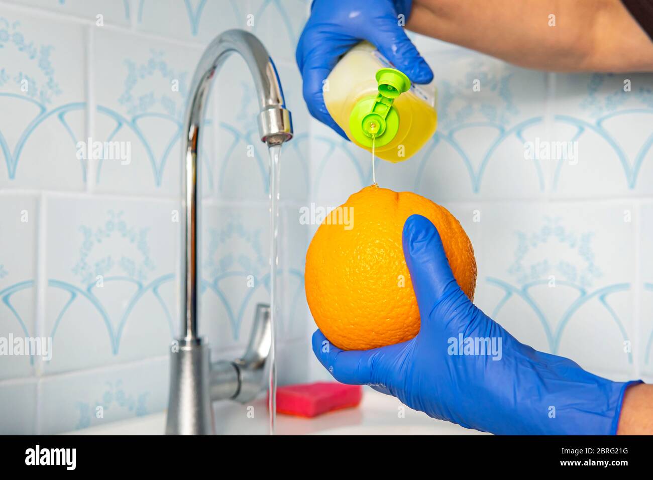 Zitrusfrüchte Sortiment Waschen in einem Leitungswasser. Leitungswasser spritzt auf Zitrusfrüchte. Früchte mit Seife von Keimen und Bakterien waschen. Stockfoto
