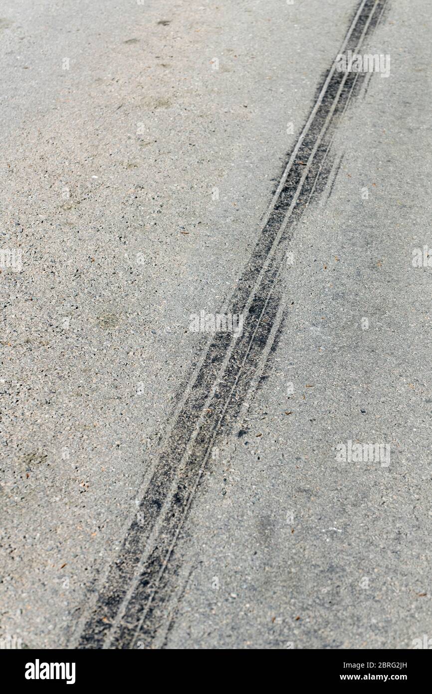 Sonnenlichtscheinte Reifenabrollmarkierung auf der Landstraße. Metapher ländlichen Verkehrsunfälle, Unfallszene. Stockfoto