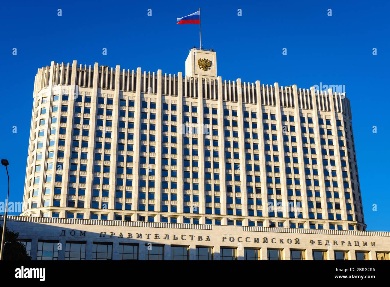 Haus der Regierung der Russischen Föderation (es ist auf der Fassade geschrieben), Moskau, Russland. Vorderansicht des Regierungsgebäudes (Weißes Haus) mit Flagge Stockfoto