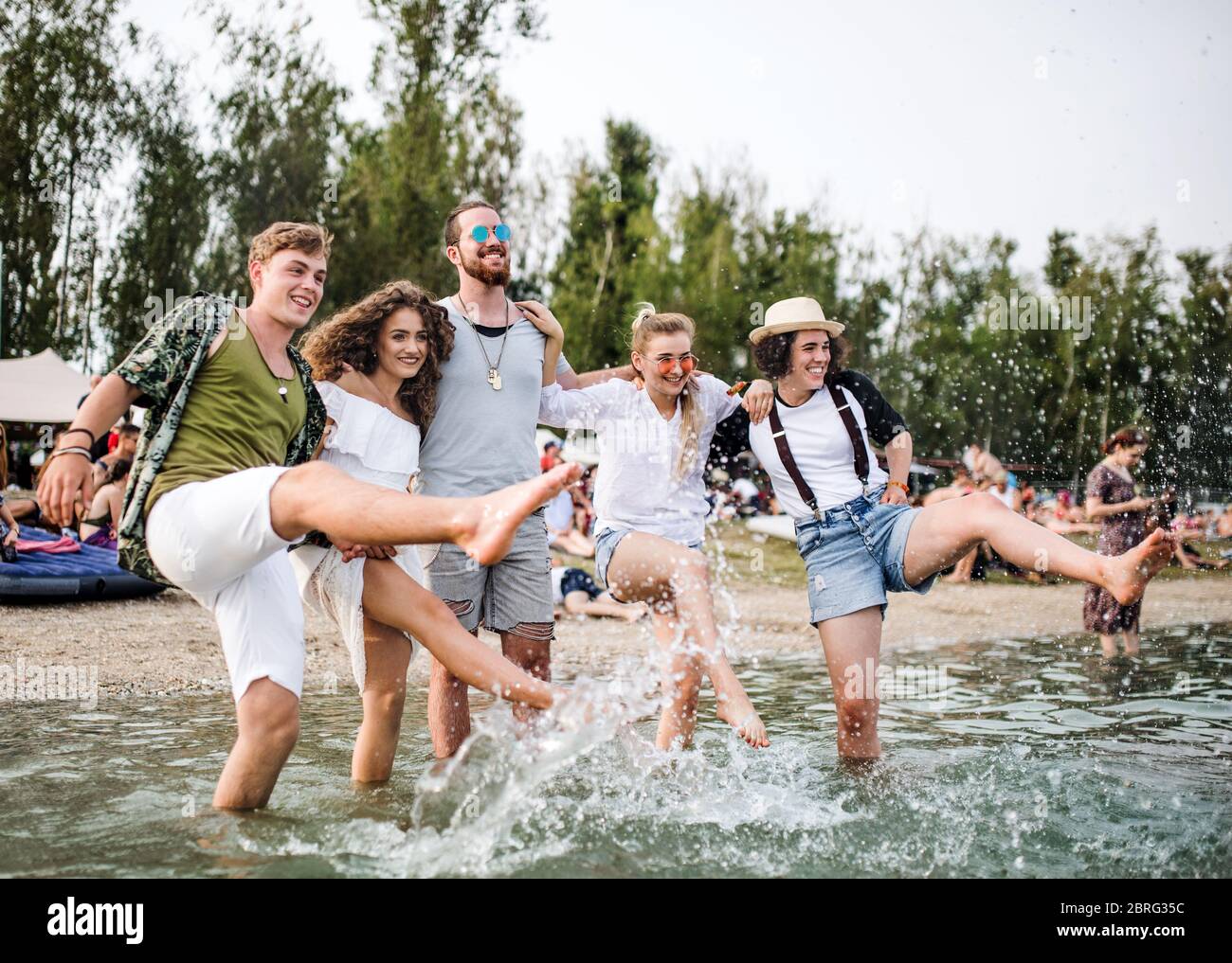 Gruppe von jungen Freunden beim Sommerfest, im See stehend. Stockfoto