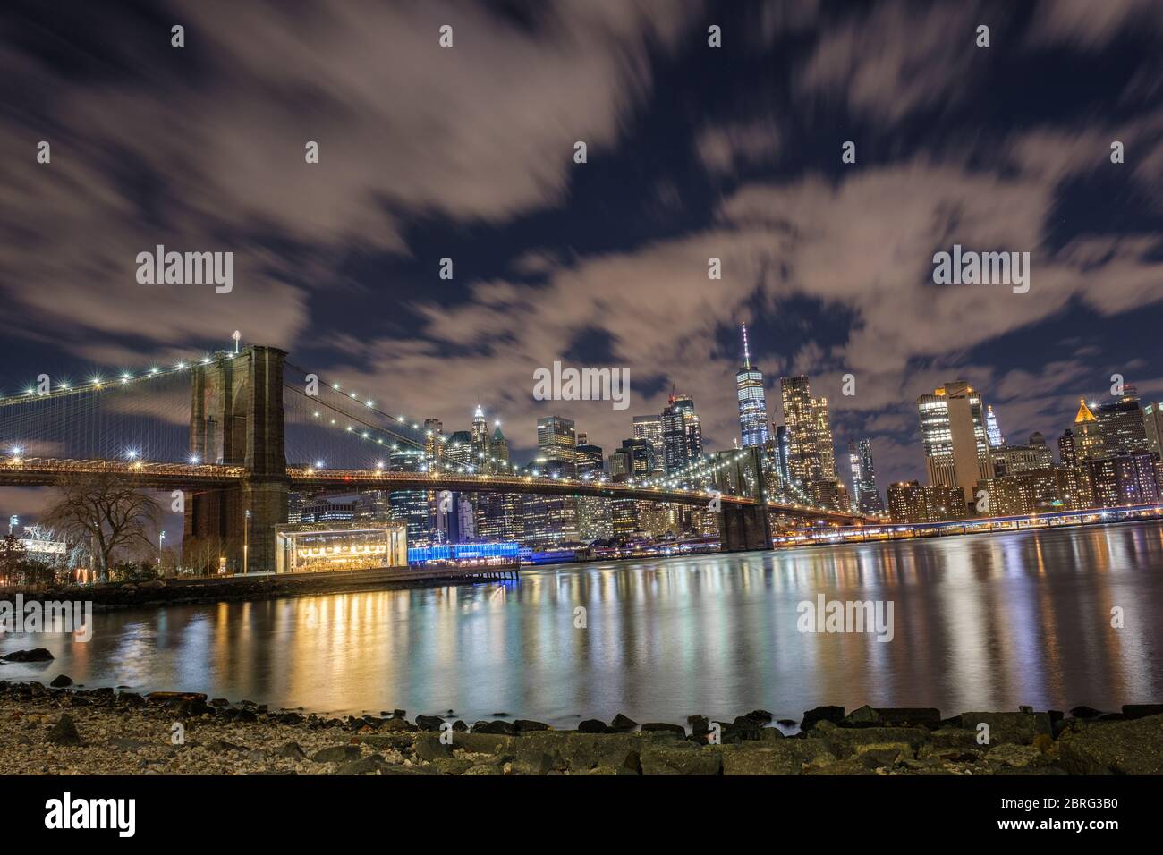 Eine lange Belichtung der Brooklyn Bridge, mit Blick auf Manhattan, aufgenommen vom Main Street Park in der Nacht, New York Stockfoto