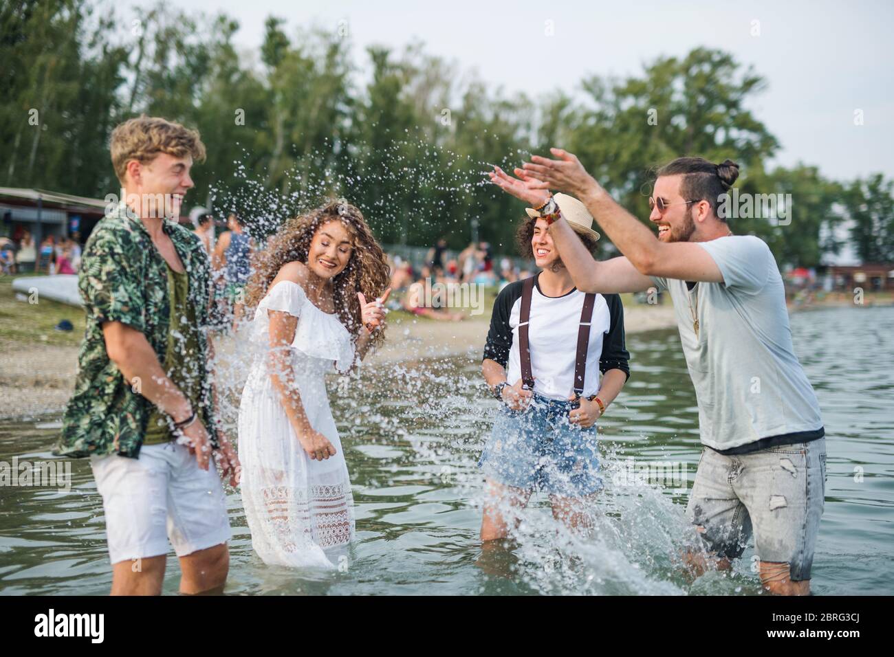 Gruppe von jungen Freunden beim Sommerfest, im See stehend. Stockfoto