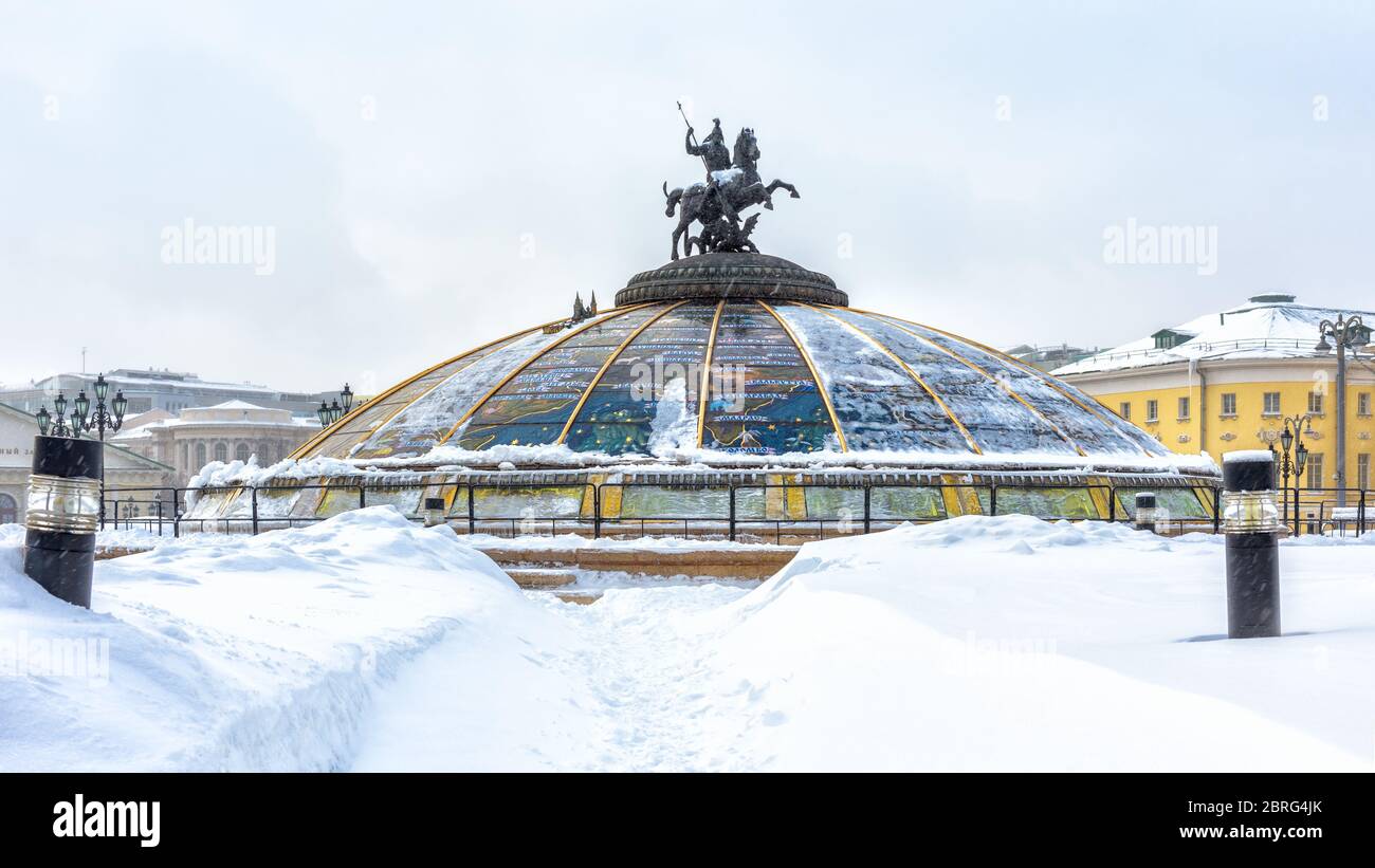 Moskau - 5. Feb 2018: Schneebedeckter Manezhnaja-Platz im Winter Moskau, Russland. Panoramablick auf die Glaskuppel mit Statue des Hl. Georg bei Schneefall. Stadt ce Stockfoto