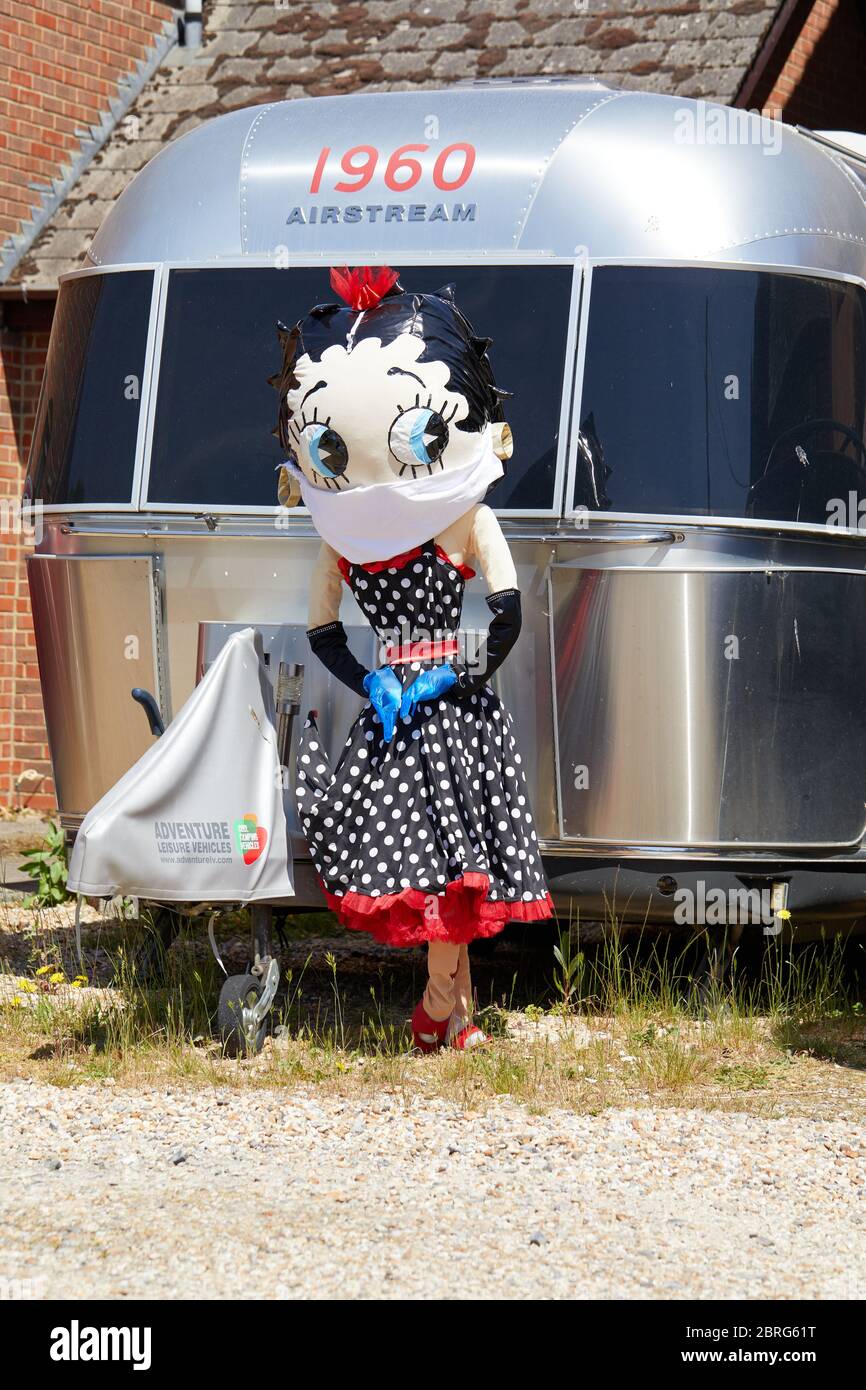 Sandleheath, Großbritannien. - 20. Mai 2020: Eine Betty Boop Vogelscheuche mit Gesichtsmaske. Das Hampshire Dorf Sandleheath veranstaltet einen jährlichen Charity Vogelscheuche Wettbewerb. Viele Einträge in diesem Jahr übernehmen ein Coronavirus Thema. Stockfoto