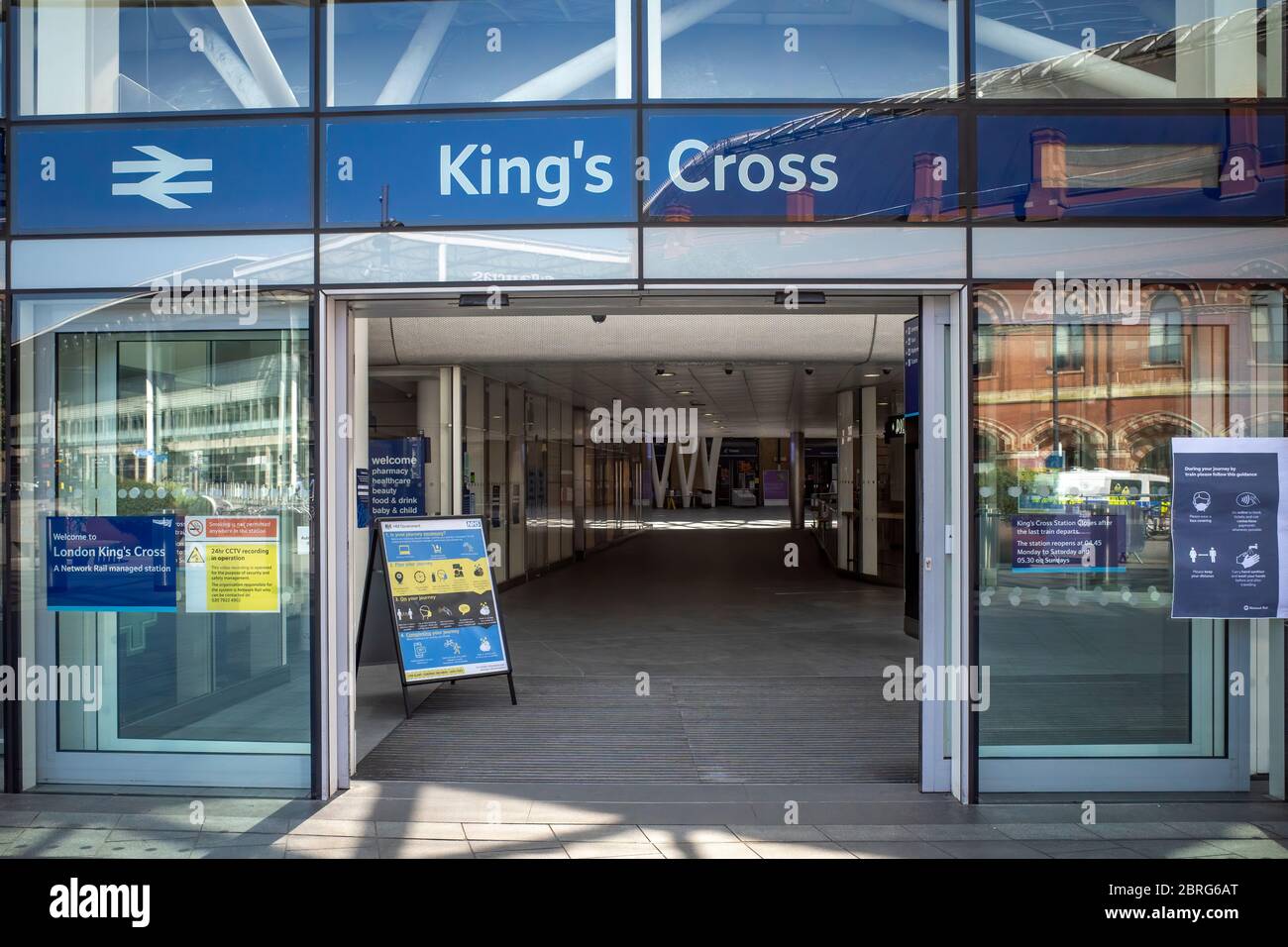 Lockdown London: 20. Mai 2020, Eintritt in eine fast leere Kings Cross Station in London mit Warnplakaten sind essentiell Reise und Coronavirus. Stockfoto