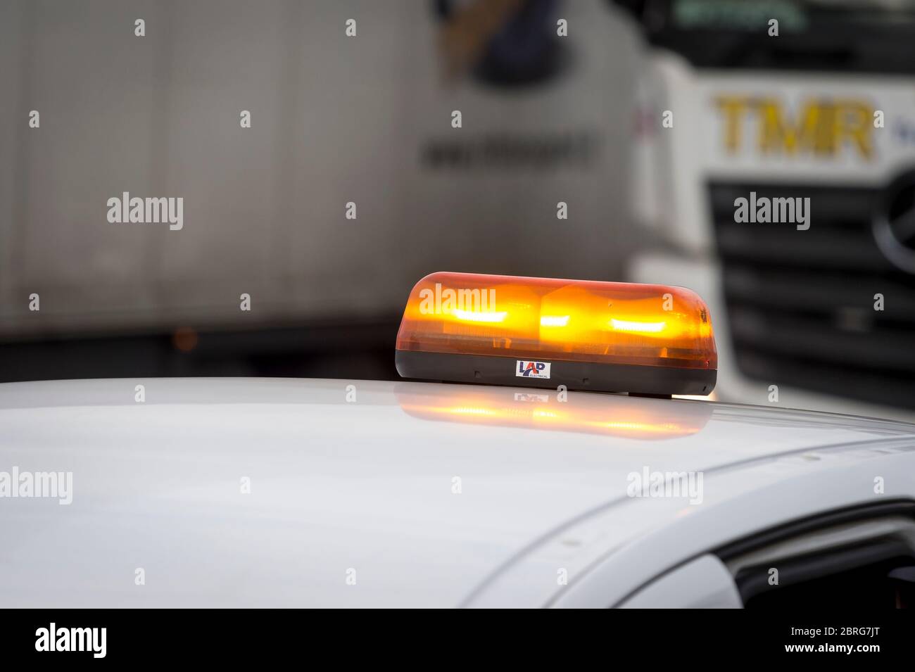 Orangefarbene Warnleuchte auf einem Wartungsfahrzeug, das durch Autobahnbaustellen in England, Großbritannien fährt. Stockfoto