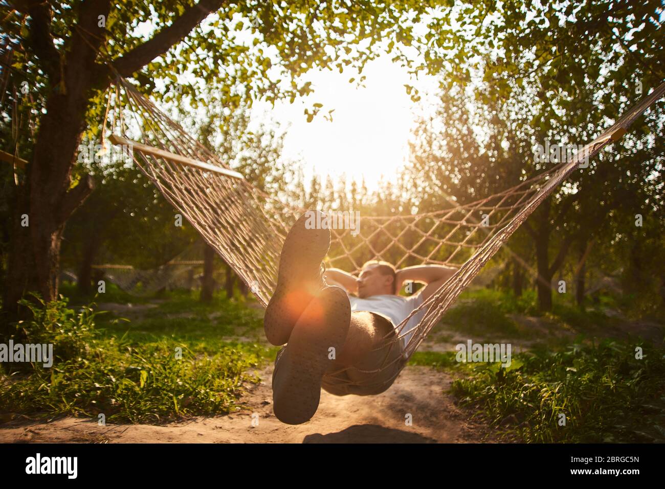 Verschwommen und Unschärfe-Entspannung in der Hängematte. Mann Ruhe im Garten. Sommer vibes im Wald Stockfoto