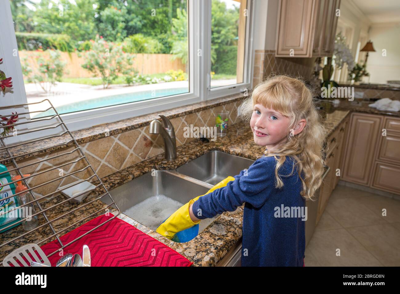 Junges 9-jähriges Mädchen, das Geschirr in der Küche, neapel, florida, usa wäscht Stockfoto