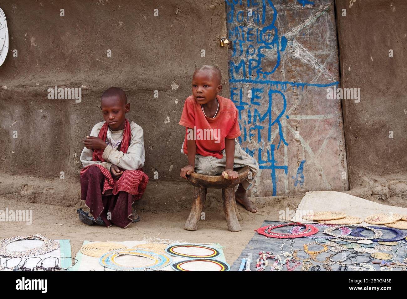 Zwei Maasai Kinder, Jungen, Verkauf von Perlen Gegenstände, traditionelle runde Schlammhaus, Stammesdorf, schmutzige Kleidung, Tansania; Afrika Stockfoto