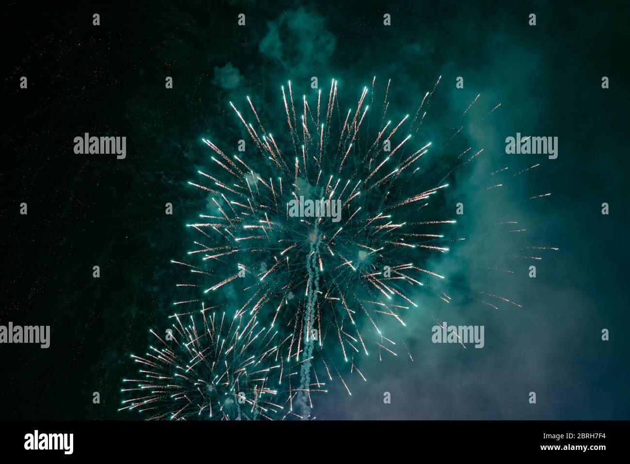 Grünes Feuerwerk mit Rauch über dem schwarzen Himmel. Geringe Tastenbelichtung. Stockfoto