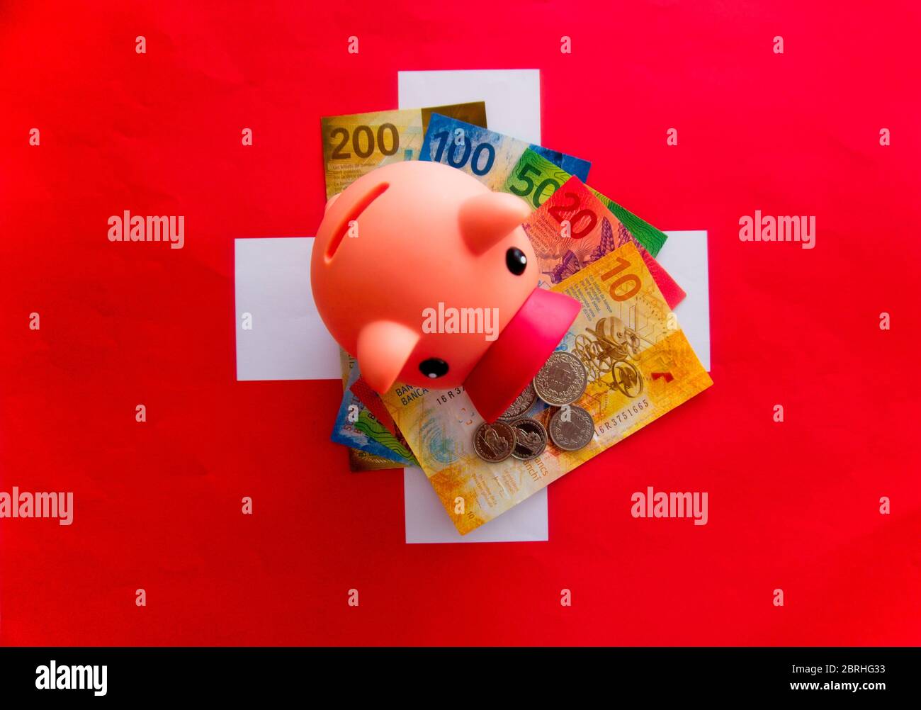 Sparschwein auf einem Wattpad Schweizer Scheine und Flagge .Schweizer Währung, Schweizer Franken Stockfoto