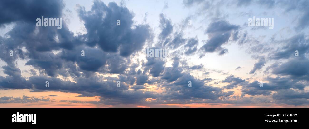 Dramatisches Panorama des Sonnenuntergangs. Grau blau stürmische Wolken bedeckt einen orangen Sonnenuntergang Himmel Nachleuchten. Landschaftlich schöne Skyscape direkt nach Sonnenuntergang. Schönheit in der Natur Stockfoto