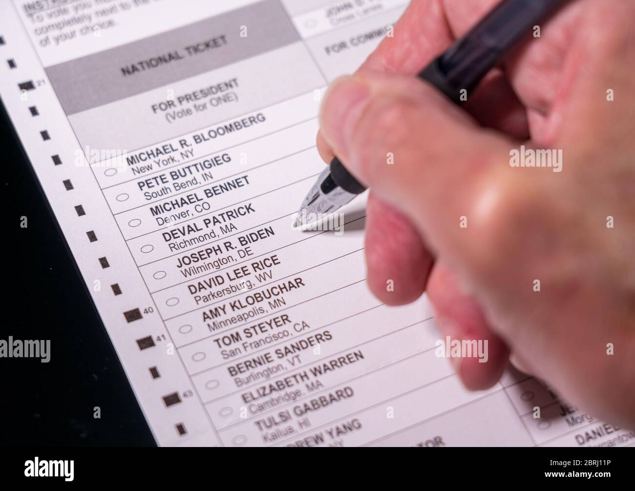 Morgantown, WV - 21. Mai 2020: Wahlurne für demokratische Primärwahlen mit Hand, die den Stift für Joe Biden für den Präsidenten hält Stockfoto