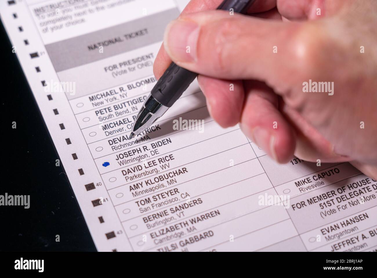 Morgantown, WV - 21. Mai 2020: Wahlurne für demokratische Primärwahlen mit Hand, die den Stift für Joe Biden für den Präsidenten hält Stockfoto