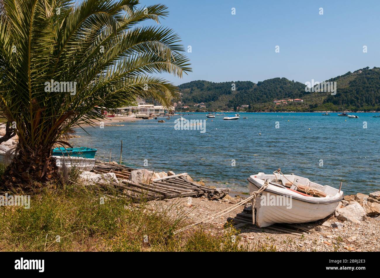 Kleines Boot auf der schönen Insel Skiathos, gelegen im tiefblauen Wasser der Ägäis. Stockfoto