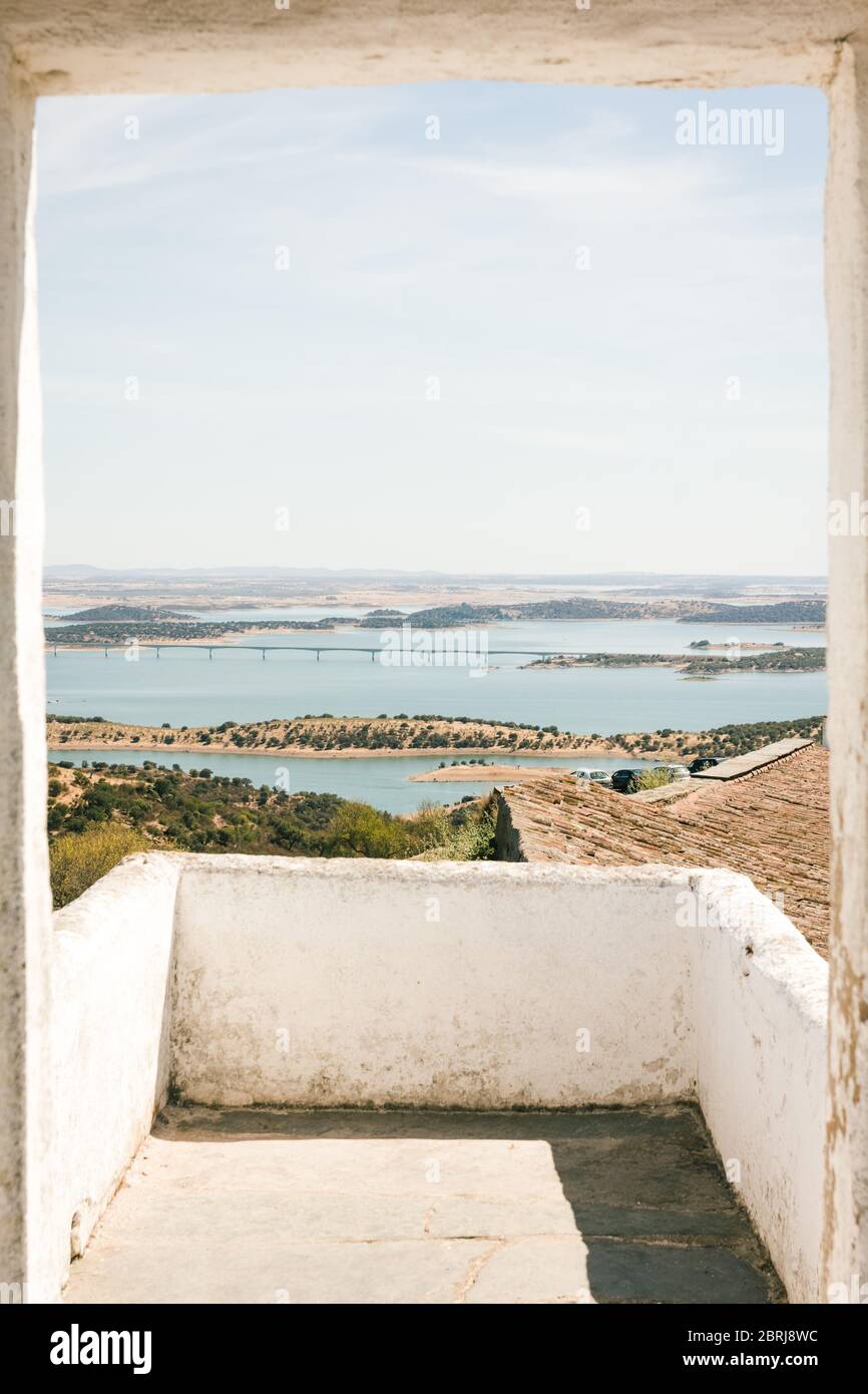Schöne Aussicht auf den Alqueva Damm, in Alentejo Portugal. Von der Einfassung einer Tür zu einem Dach im Dorf Monsaraz gesehen. Reisen im Mittelmeerraum Stockfoto