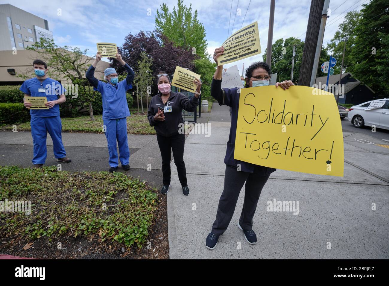 Portland, USA. Mai 2020. Am 21. Mai 2020 halten Beschäftigte im Gesundheitswesen vor dem Legacy Emmanuel Medical Center in Portland, Oregon, Schilder, während Autos das Krankenhaus umfahren, um Unterstützung für die wichtigsten Beschäftigten zu zeigen. (Foto: Alex Milan Tracy/Sipa USA) Quelle: SIPA USA/Alamy Live News Stockfoto