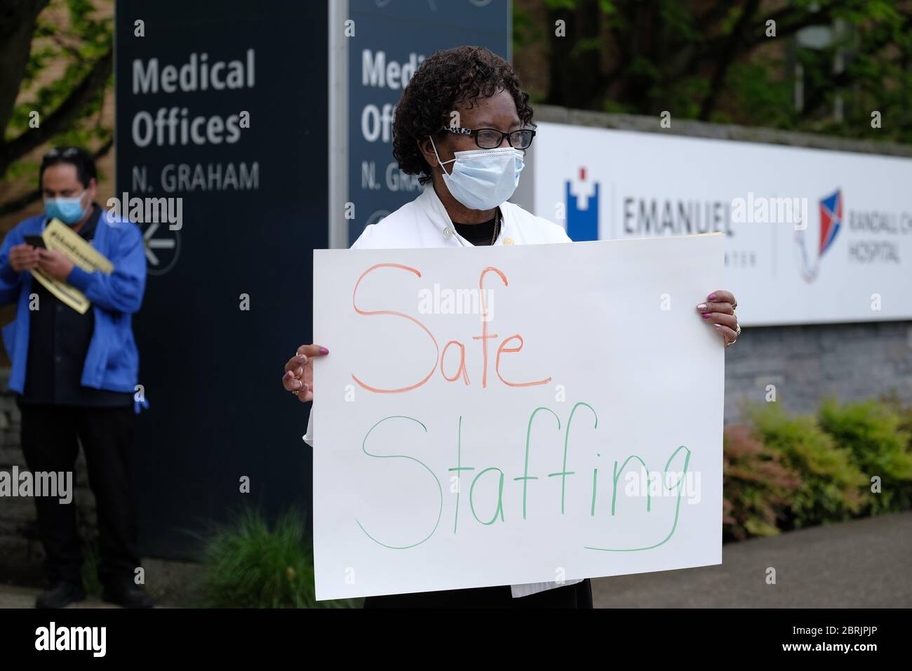 Portland, USA. Mai 2020. Violet Hall, ein Koch, schließt sich den Beschäftigten des Gesundheitswesens an, während sie am 21. Mai 2020 vor dem Legacy Emmanuel Medical Center in Portland, Oregon, Schilder halten, während Autos das Krankenhaus umfahren, um Unterstützung für die wichtigsten Arbeiter zu zeigen. (Foto: Alex Milan Tracy/Sipa USA) Quelle: SIPA USA/Alamy Live News Stockfoto