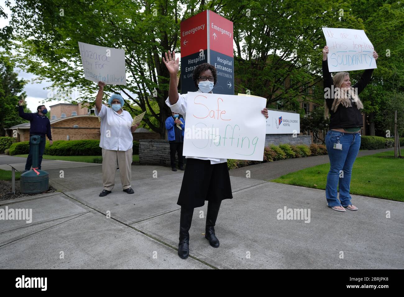 Portland, USA. Mai 2020. Am 21. Mai 2020 halten Beschäftigte im Gesundheitswesen vor dem Legacy Emmanuel Medical Center in Portland, Oregon, Schilder, während Autos das Krankenhaus umfahren, um Unterstützung für die wichtigsten Beschäftigten zu zeigen. (Foto: Alex Milan Tracy/Sipa USA) Quelle: SIPA USA/Alamy Live News Stockfoto