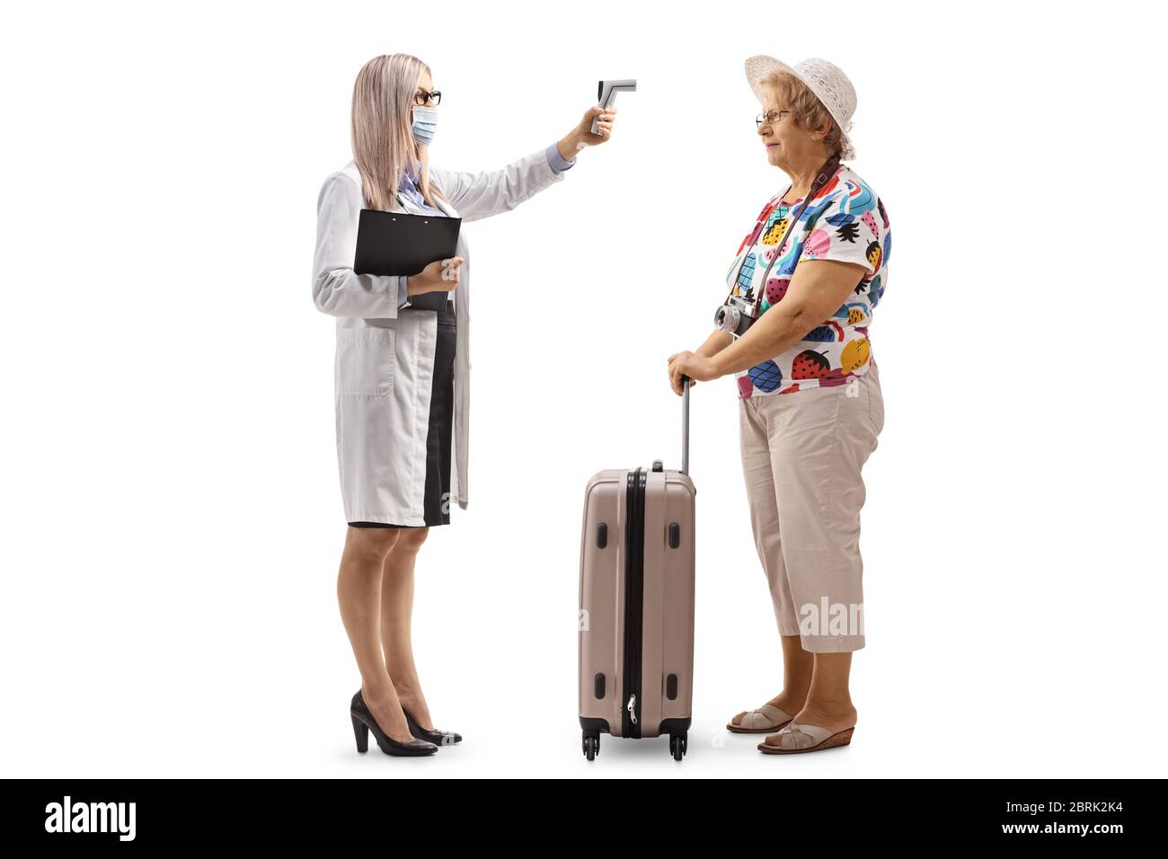 Full length Profil Aufnahme einer Ärztin mit einem Thermometer Messung der Temperatur zu einer älteren Frau mit einem Koffer isoliert auf weißem Hintergrund Stockfoto