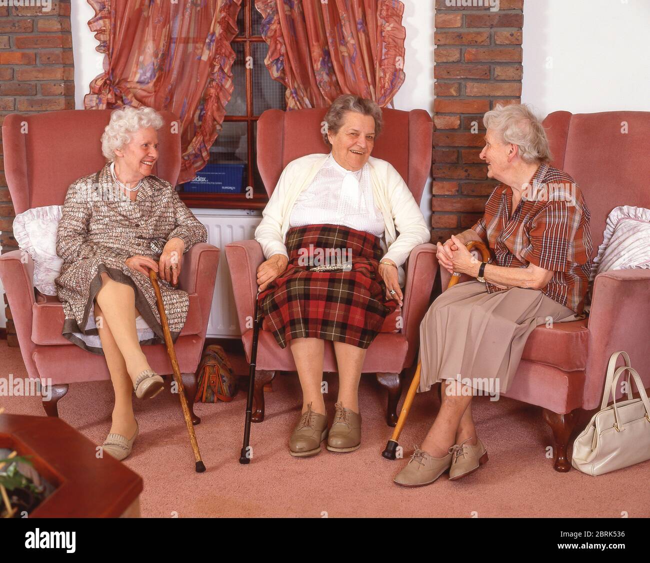 Ältere Frau, die sich im Pflegeheim, Surrey, England, Großbritannien unterhält Stockfoto