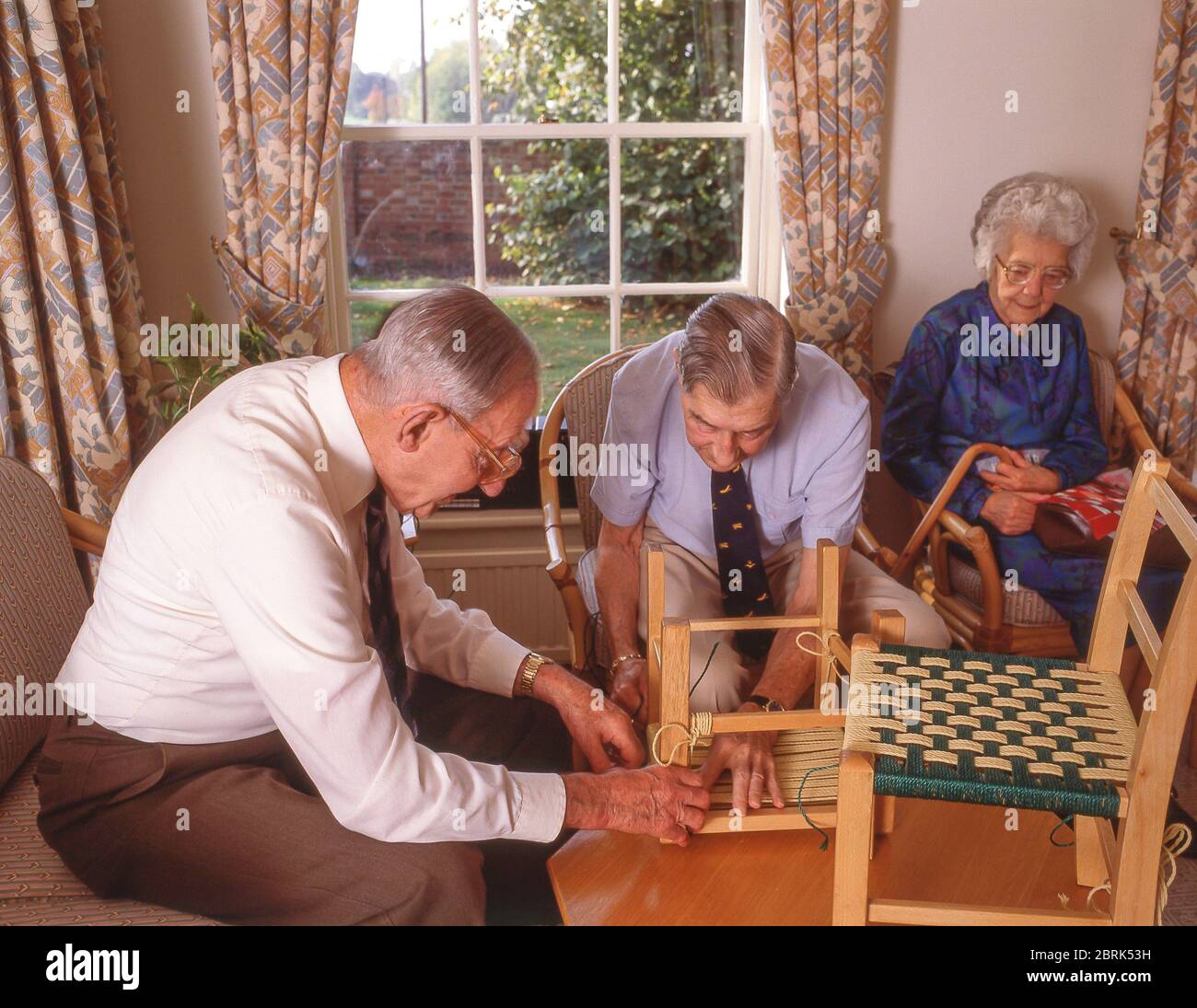 Seniorenbewohner, die Stuhlbezüge in Pflegeheimen, Surrey, England, Vereinigtes Königreich Stockfoto