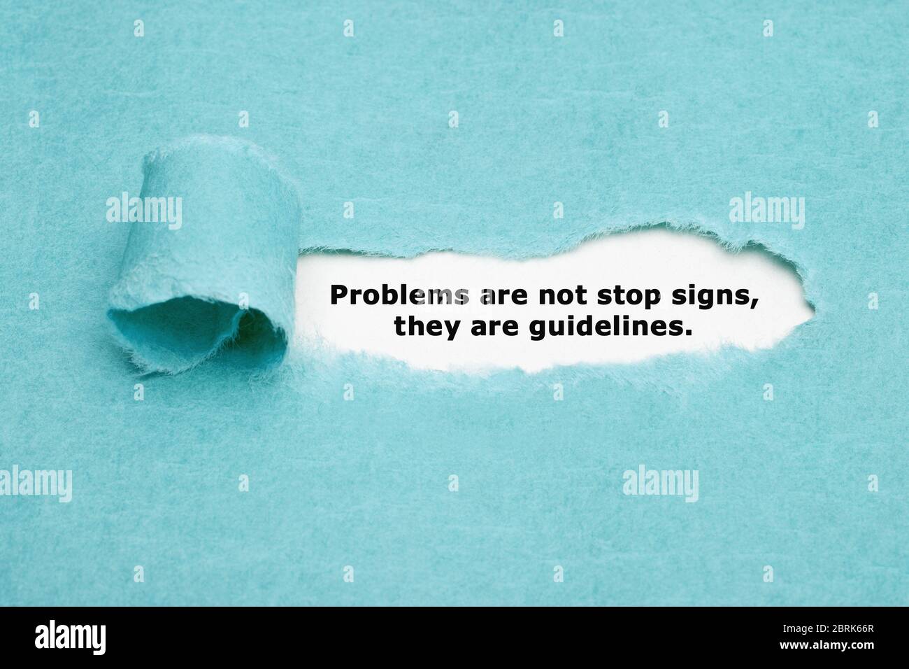 Inspirierende Zitatsprobleme sind keine Stoppschilder, sondern Richtlinien, die hinter zerrissenem blauem Papier erscheinen. Stockfoto