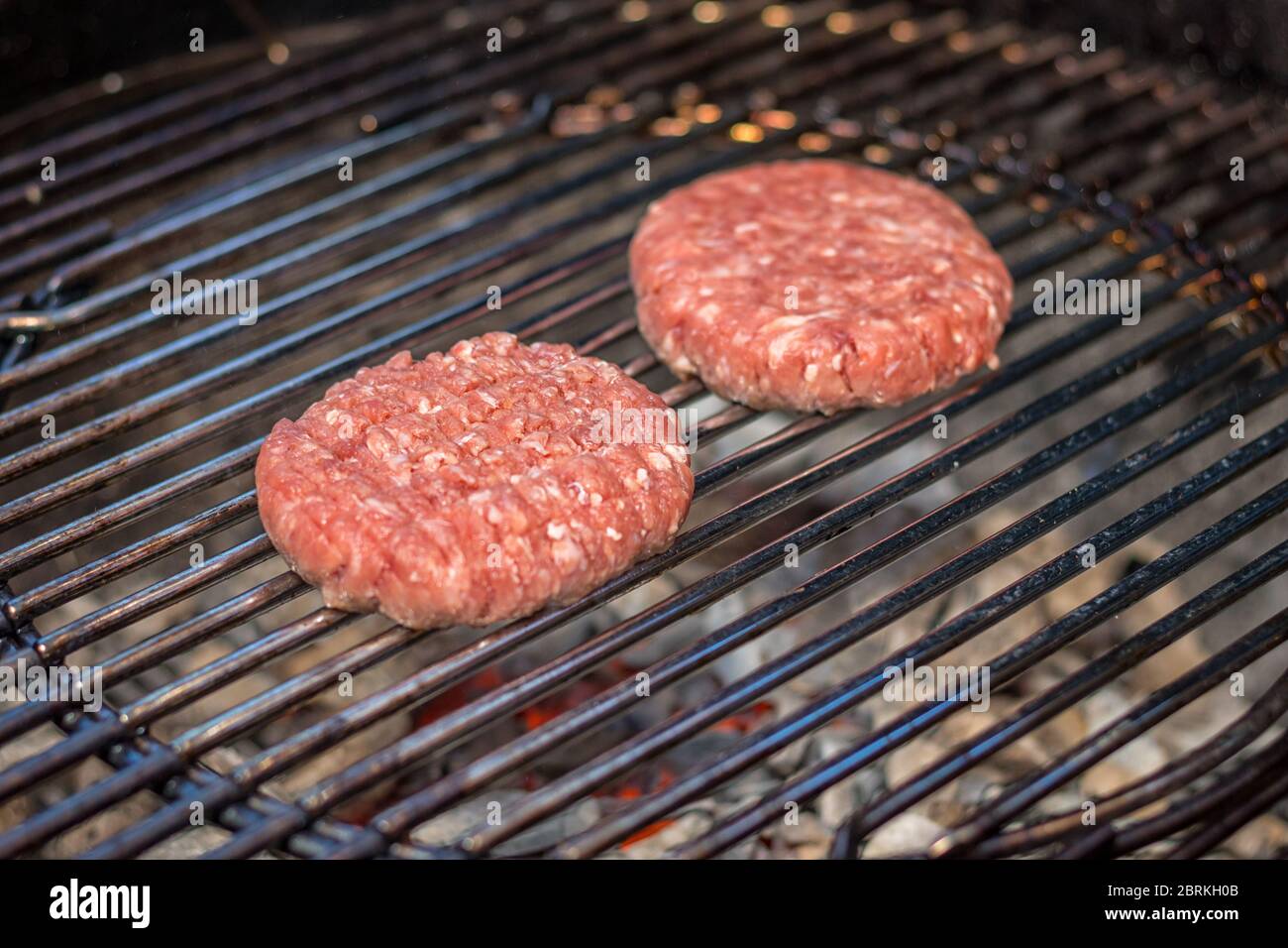 Gegrilltes Fleisch: Zwei Burger auf einem Grill im Freien Stockfoto