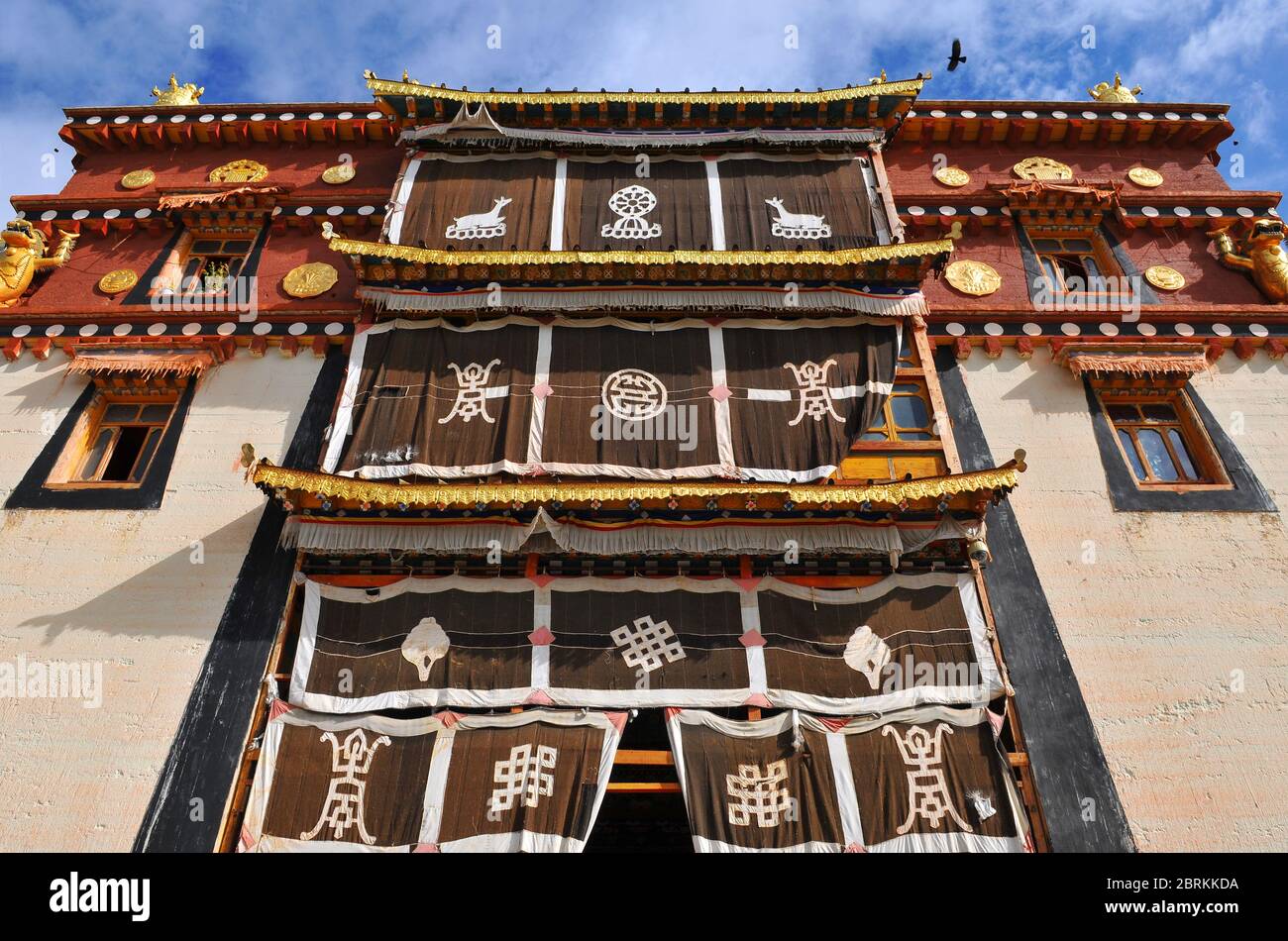 Ein Gebäude mit tibetisch-buddhistischen Motiven und Dekorationen im Kloster Songzanlin, Shangri La oder Zhongdian, Yunnan, China. Stockfoto