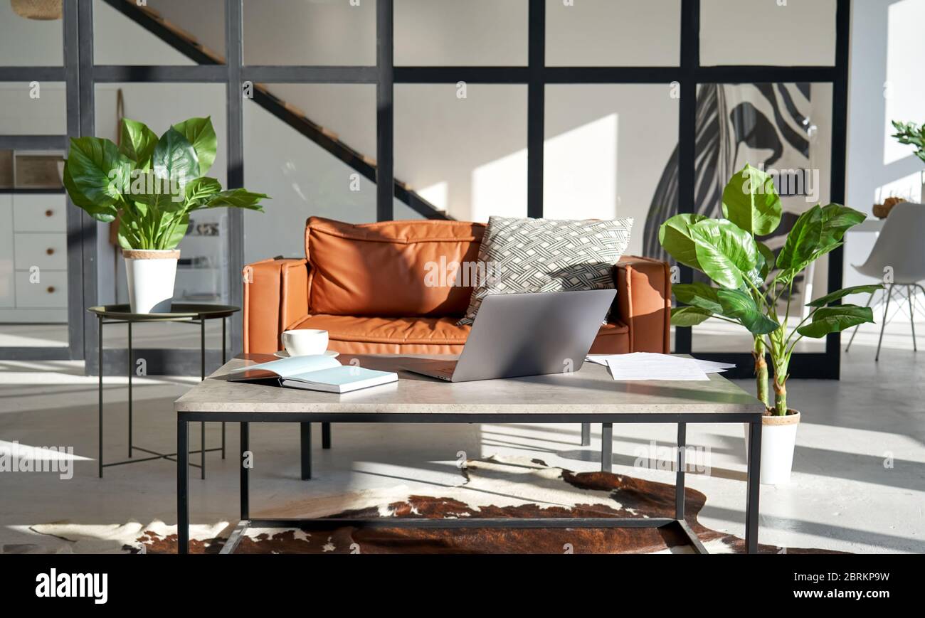 Modernes, sonniges Wohnzimmer mit Innenarchitektur und Home Office Arbeitsplatz und Sofa. Stockfoto