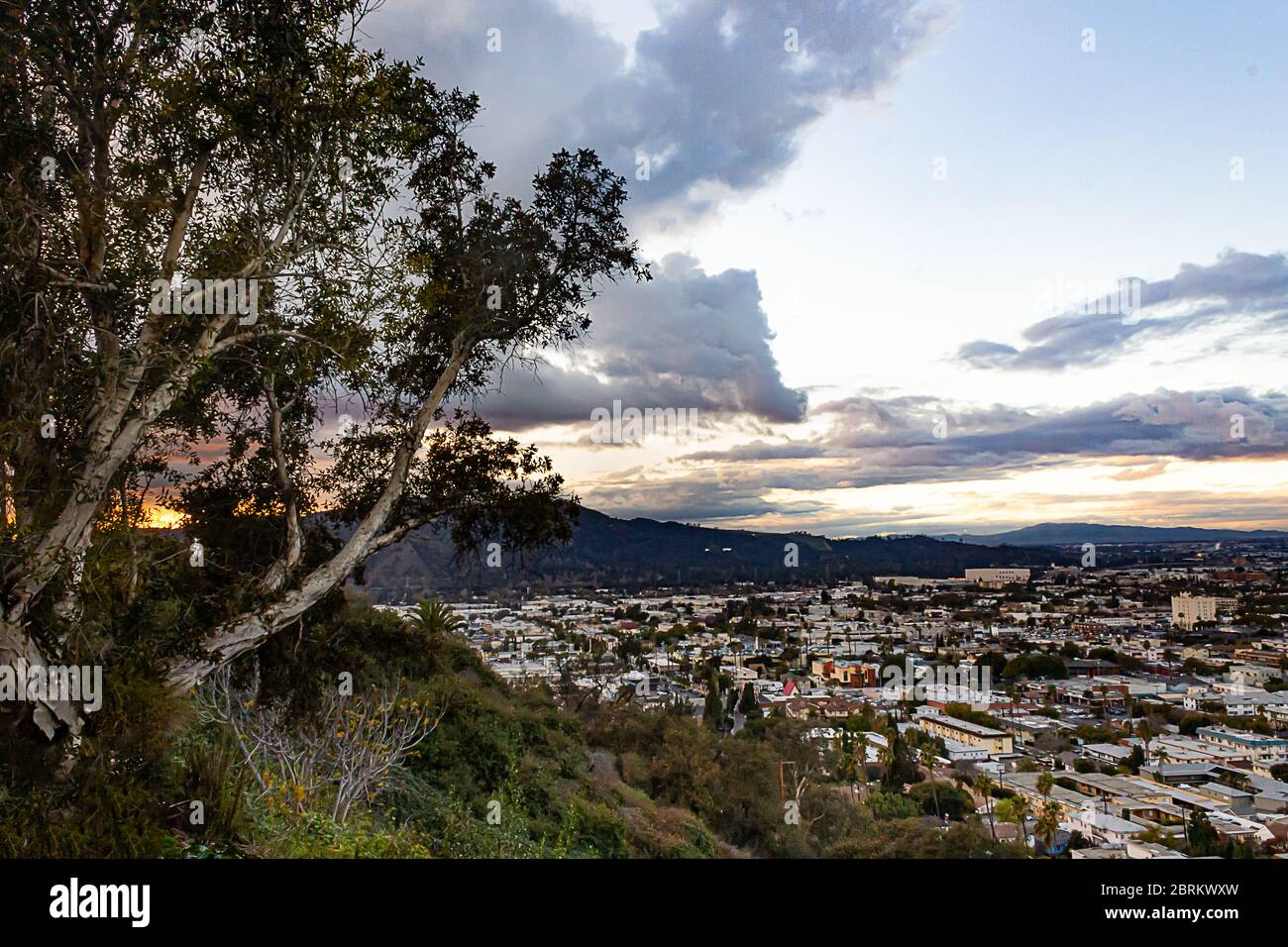 Luftaufnahme des san gabriel Berges mit Stadt Ausbreitung durch das Tal und Wolken bei Sonnenuntergang Stockfoto