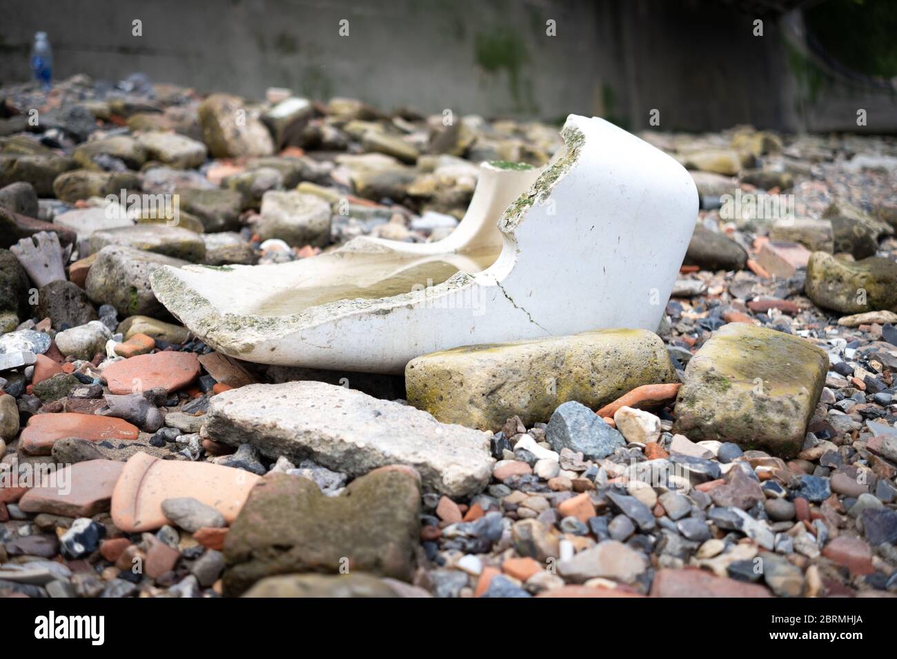 Kaputte Toilettenzisterne, die am Ufer der Themse weggeworfen wurde Stockfoto
