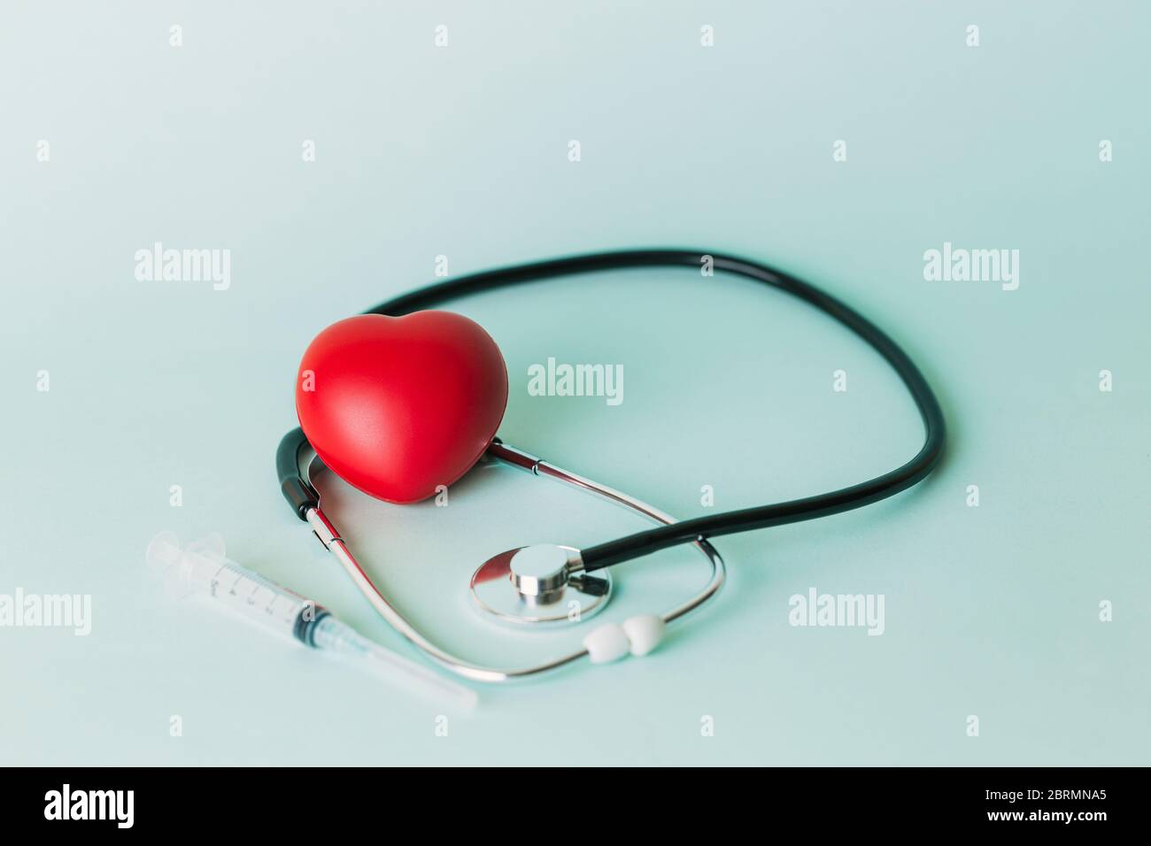 Eine sterile Spritze neben einem Stethoskop und eine rote Herz Stockfoto