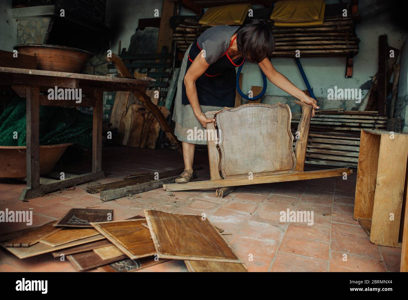 Weibliche Handwerker arbeiten Wiederverwendung von alten Holzmöbeln für den künstlerischen Gebrauch Stockfoto