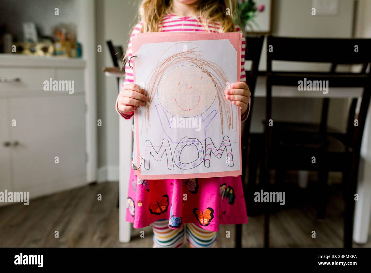 Junges Mädchen hält eine Zeichnung, die sie von ihrer Mutter gemacht Zum Muttertag Stockfoto