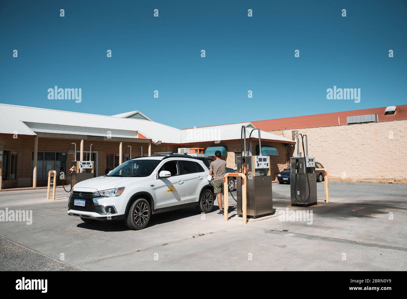 Denham, Nov 2019: Mann Tourist füllt Mietauto mit Benzin an der Tankstelle auf. Tanken eines Autos mit Benzin an der Selbstbedienungs-Tankstelle Stockfoto