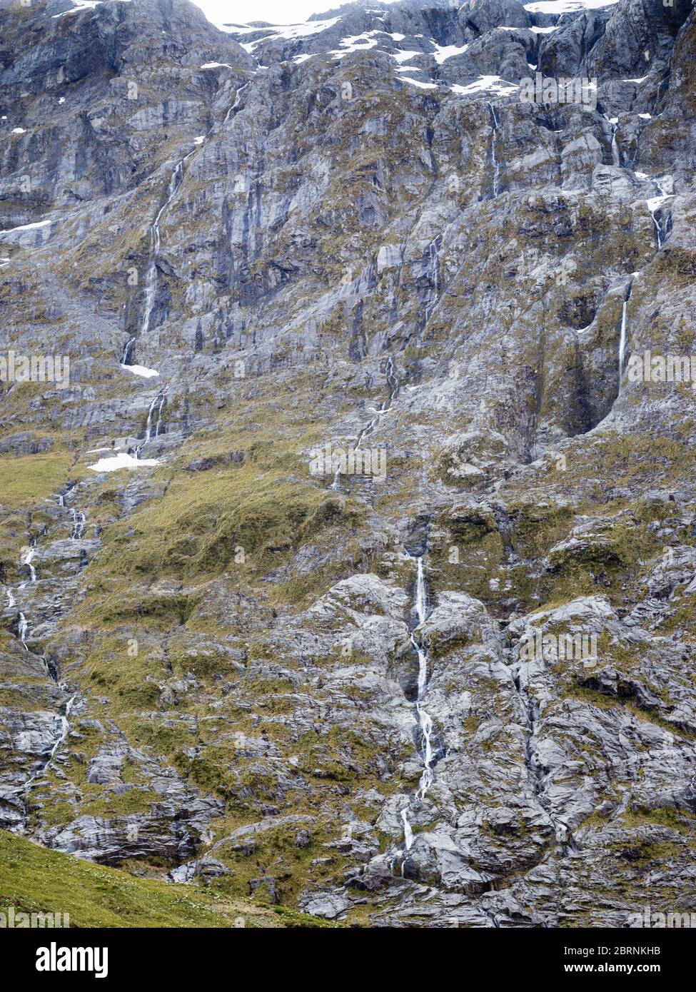 Schneeschmelzwasserfälle, die an der Seite des Mt Crosscut, Gertrude Valley, Darran Mountains, Fiordland National Park, South Island, Neuseeland hinunterströmen Stockfoto